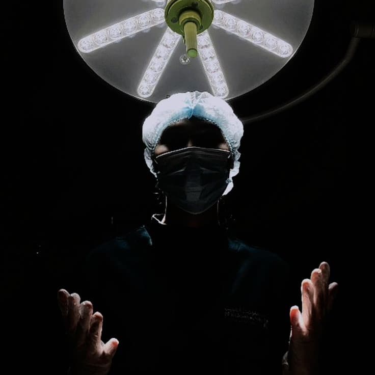Surgeon standing under operating lights